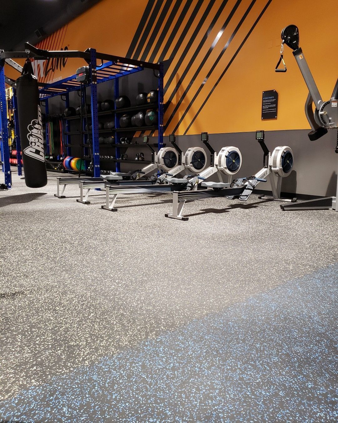 A gym with a lot of exercise equipment on the floor