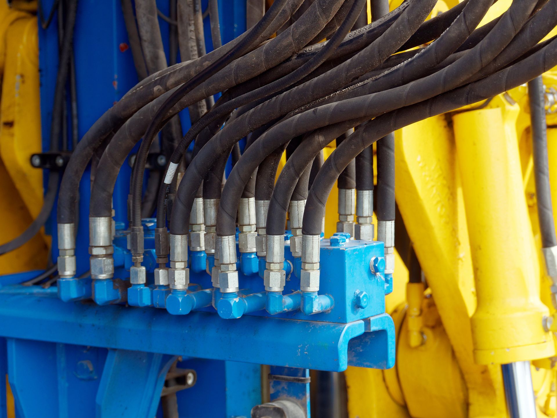 A bunch of hydraulic hoses are connected to a machine.
