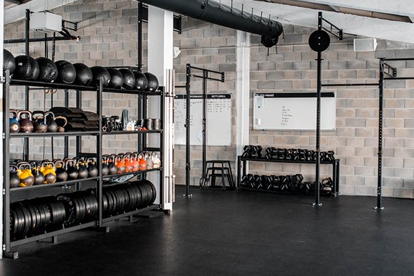 There are a lot of dumbbells on the shelves in this gym.