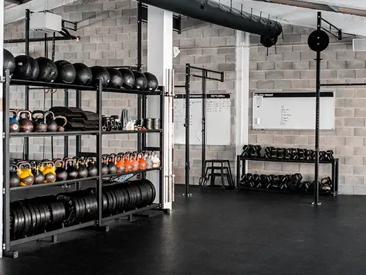 A gym filled with lots of weights and a white board.