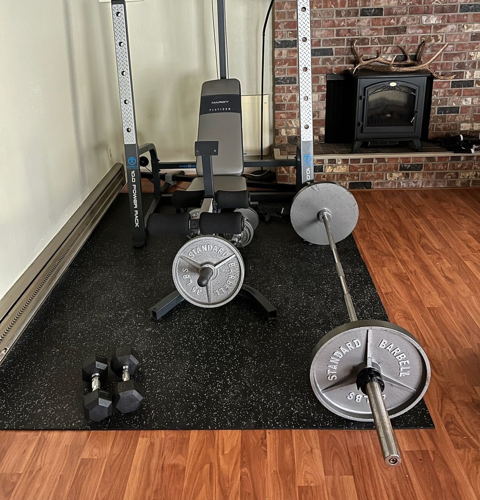 A gym with a barbell and dumbbells on the floor