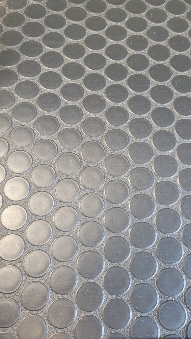 A close up of a black tile floor with circles on it.