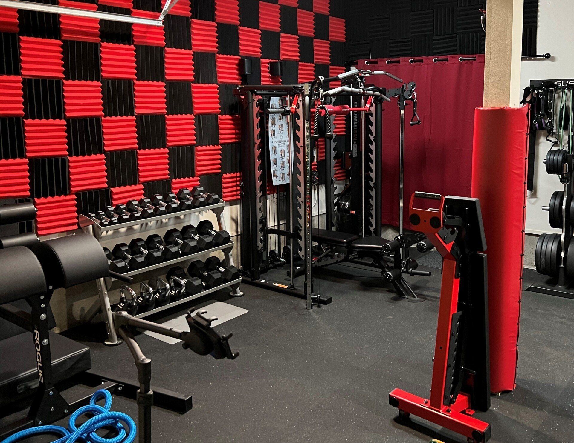 A gym with a lot of equipment and a checkered wall.