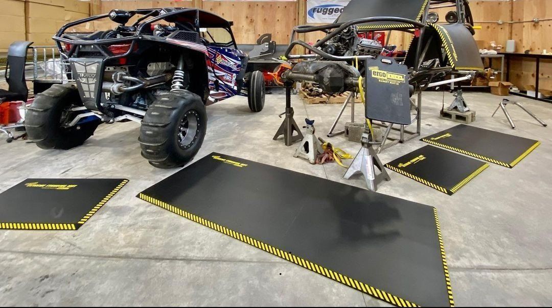 A dune buggy is being worked on in a garage.