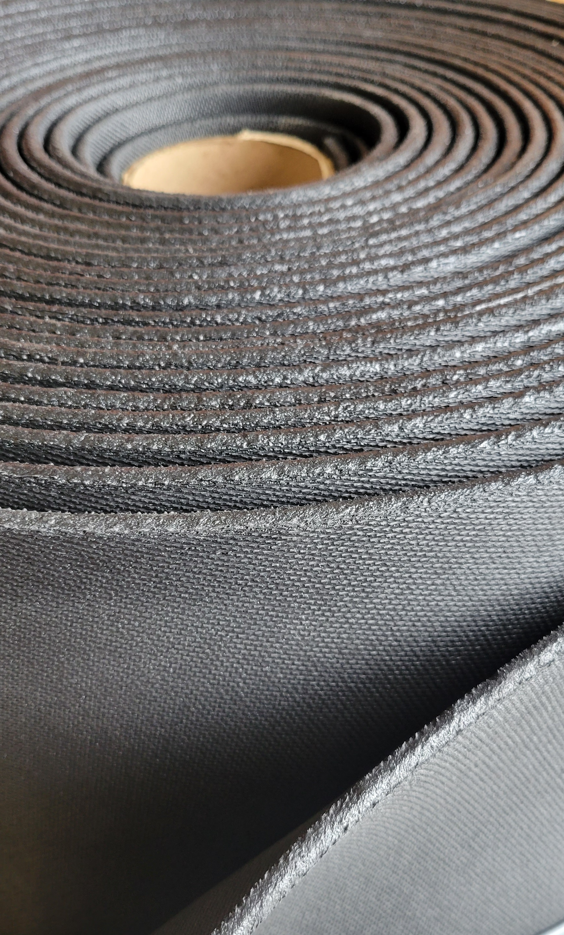 A close up of a roll of black fabric on a table.