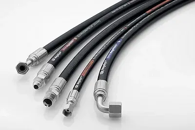 A group of hydraulic hoses sitting on top of each other on a white surface.