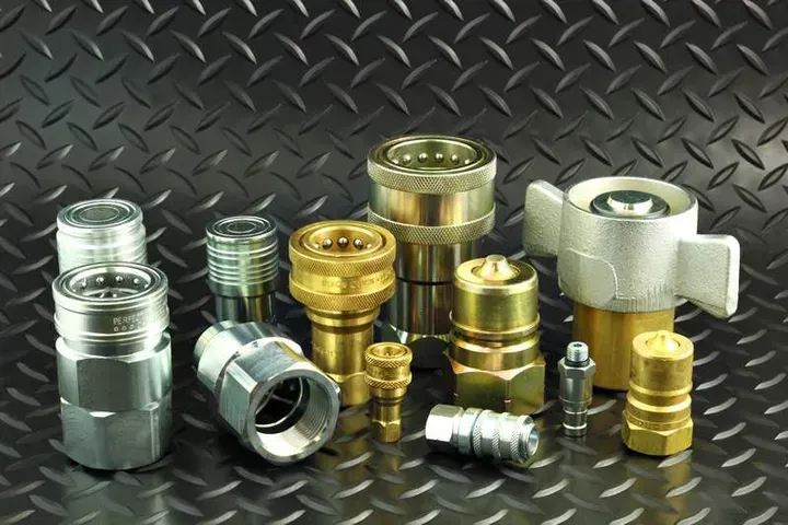 A group of hydraulic fittings are sitting on a metal surface.
