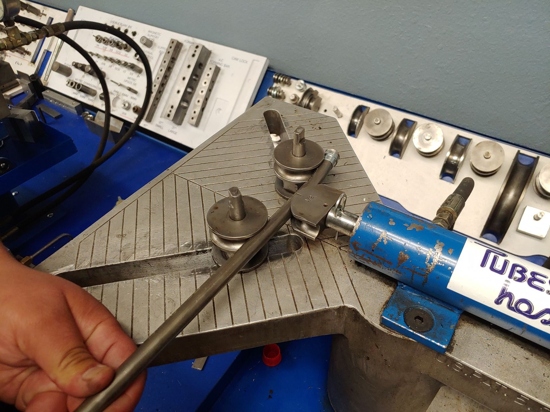 A person is using a tube bending machine on a table