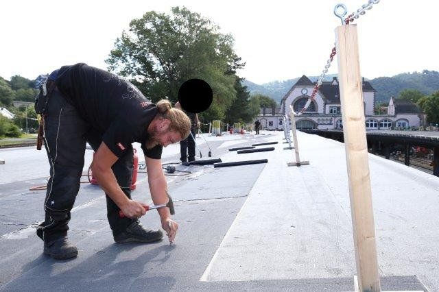 Dachdecker arbeitet am Dach vom Bahnhof Bad Harzburg