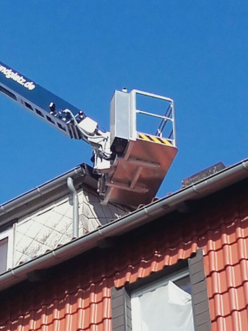 Kran bei Arbeiten an einem Dach