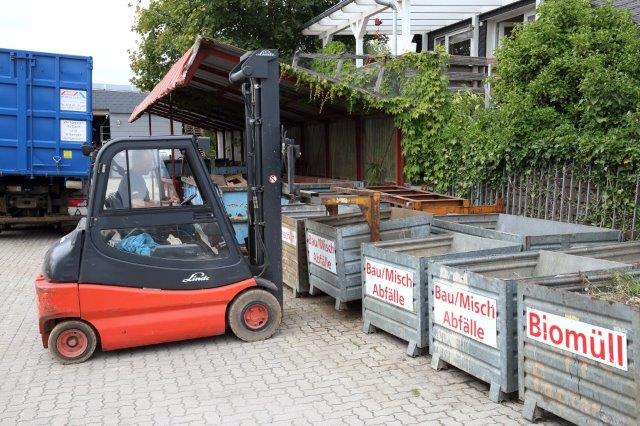Roter Gabelstaplet bei Abfall Containern