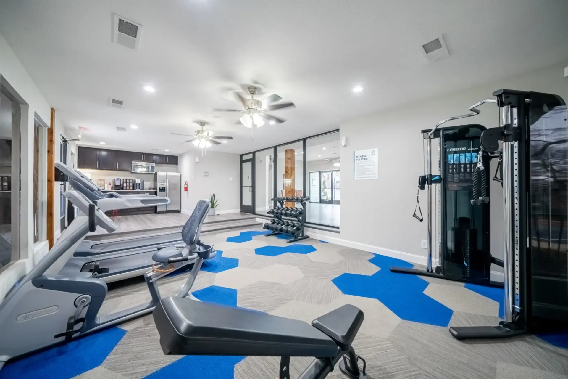 A gym with treadmills , exercise bikes , and a bench.