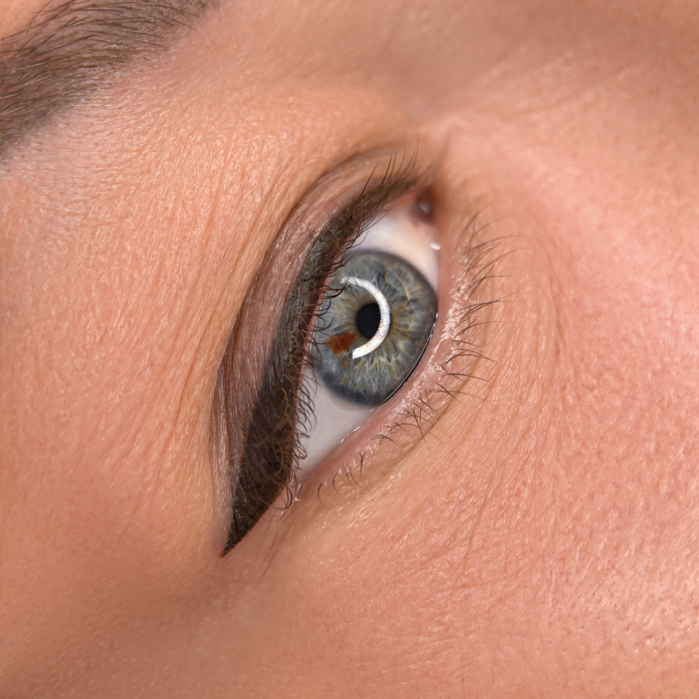 A close up of a woman 's blue eye with eyeliner.
