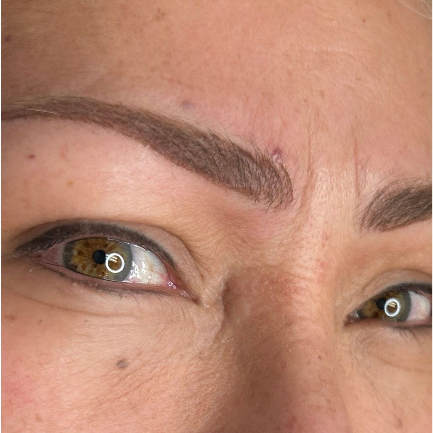 A close up of a woman 's face with gray hair and freckles.