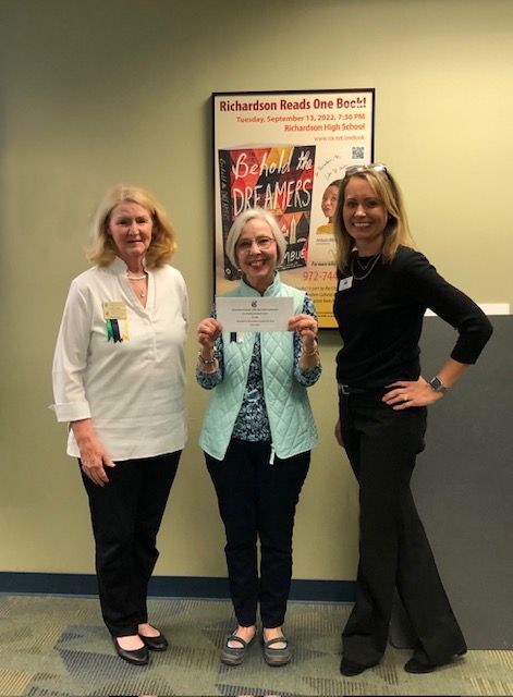 Three women standing next to each other in front of a sign that says school & therapy