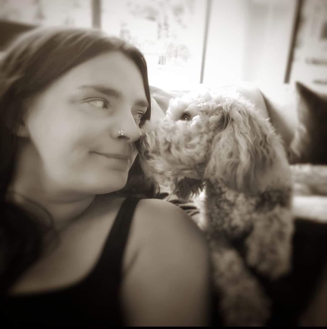 A woman with a small dog on her shoulder