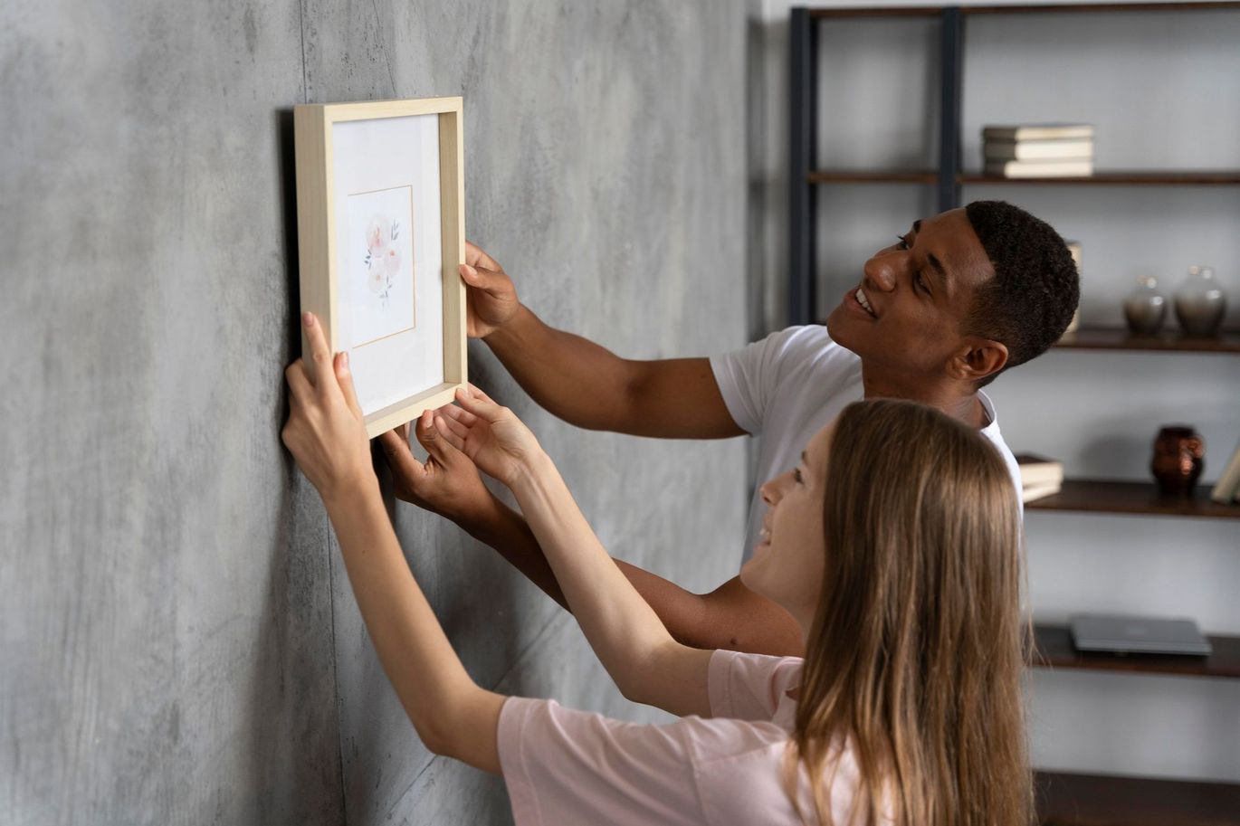 family hanging a picture on the wall