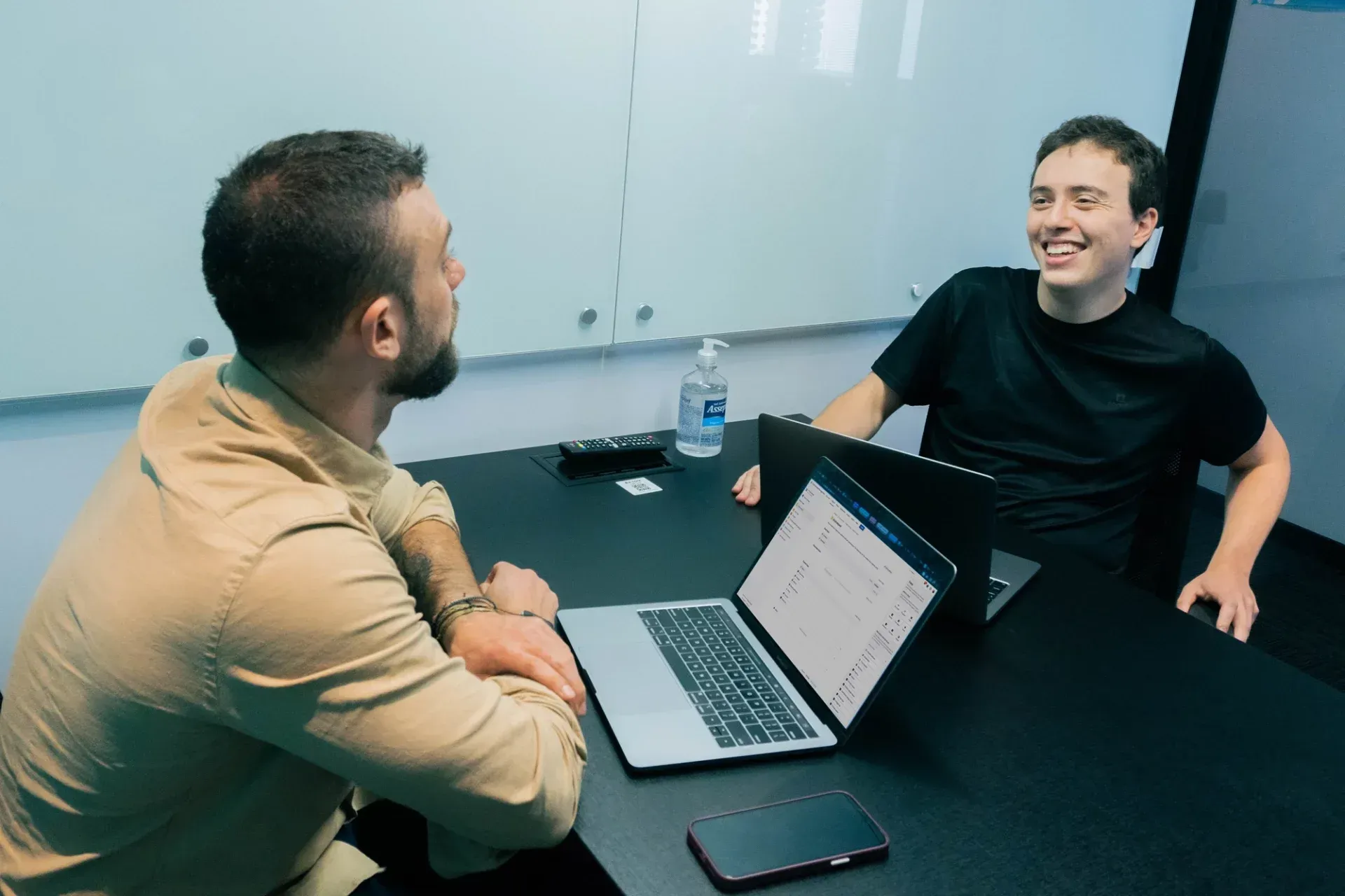 Dois homens sentados em uma mesa usando o Jira Service