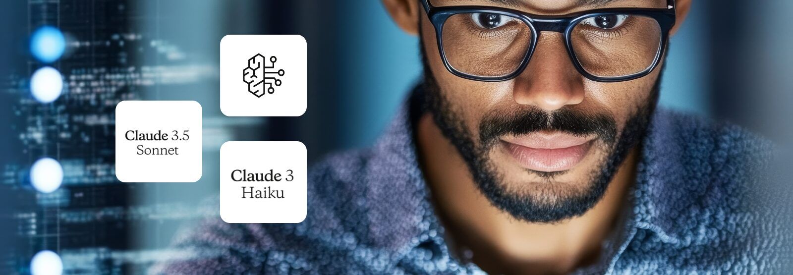 A man with glasses and a beard is looking at a computer screen.