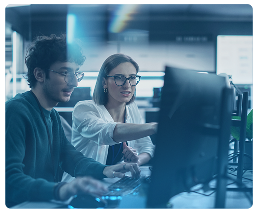 Um homem e uma mulher estão olhando para uma tela de computador.