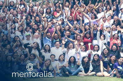 Um grande grupo de pessoas está posando para uma foto com as mãos no ar.