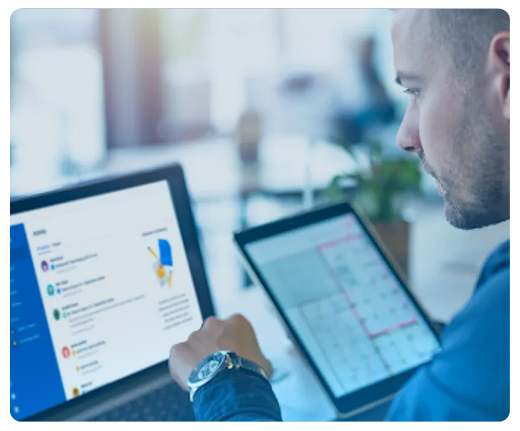 Um homem está usando um laptop e um tablet ao mesmo tempo