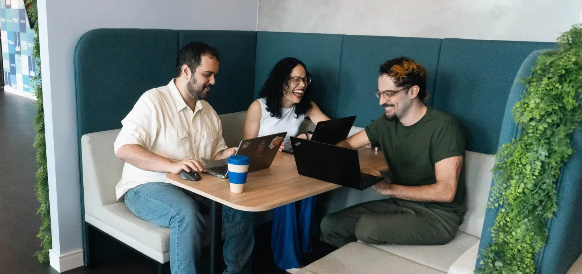 A group of people are sitting at a table with laptops.