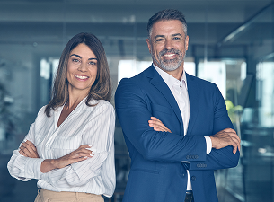 Um homem e uma mulher estão de pé, um ao lado do outro, com os braços cruzados.