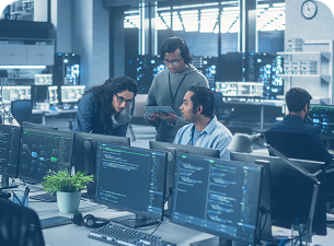 Um grupo de pessoas está trabalhando em computadores em um escritório.