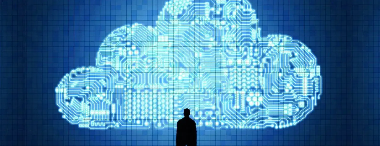 A man is standing in front of a cloud made of circuit boards.