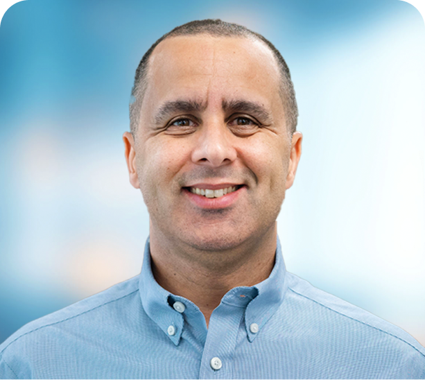 A man in a blue shirt is smiling for the camera.