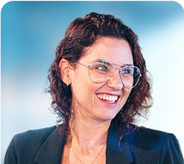 A woman wearing glasses and a black jacket is smiling.
