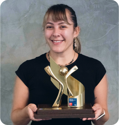 A woman in a black shirt is holding a trophy