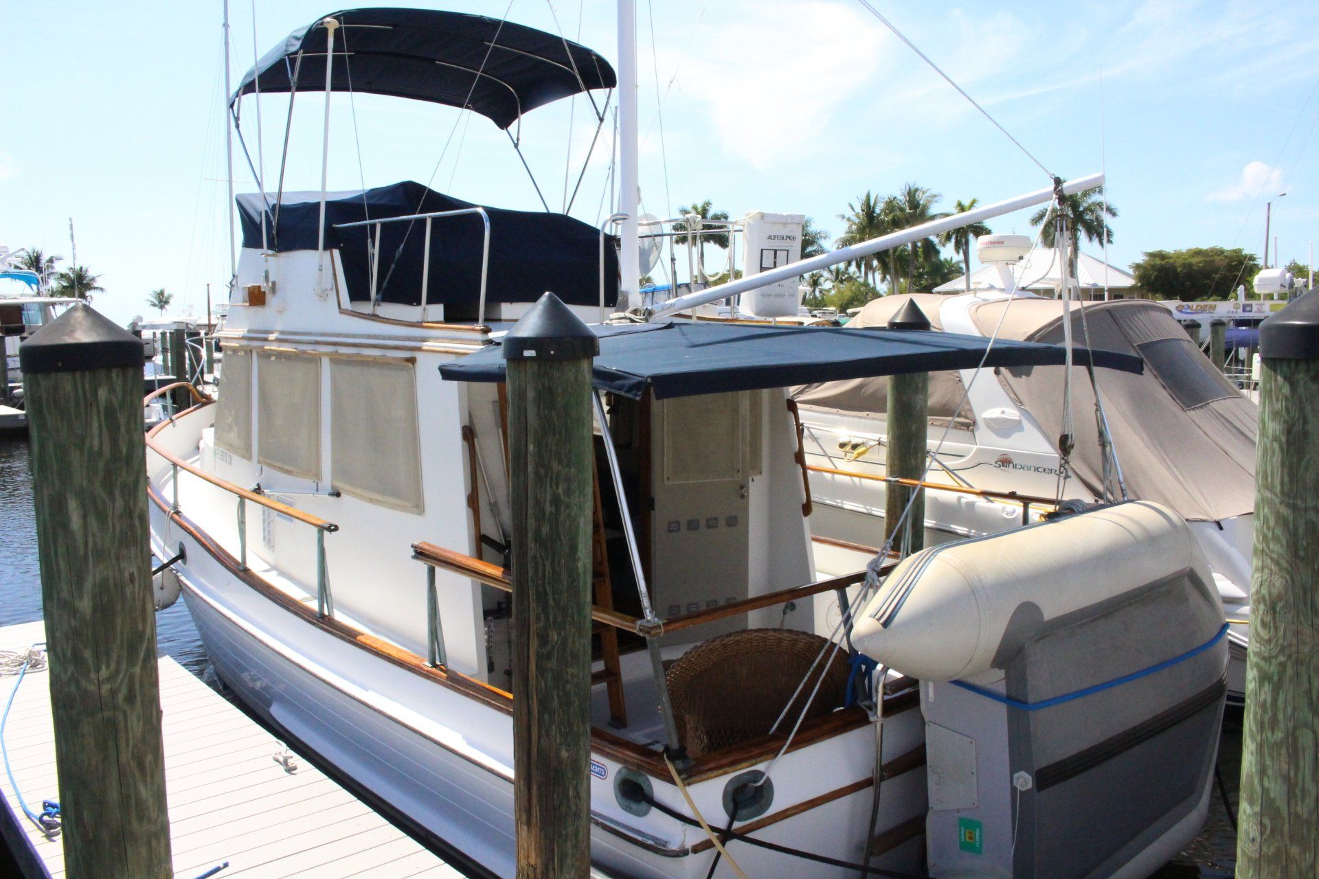 A boat with a canopy is docked at a marina