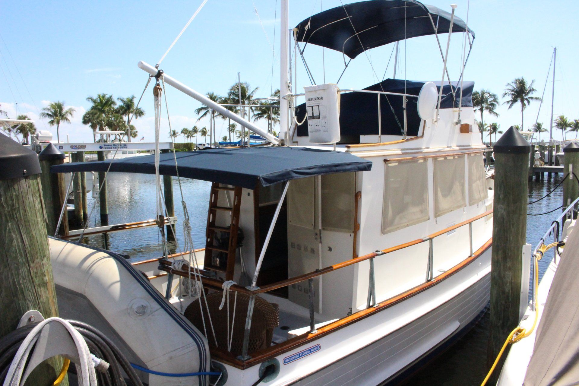 A boat is docked at a dock with a blue canopy