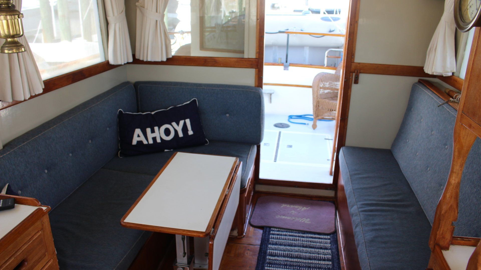 A couch with a pillow that says ahoy on it