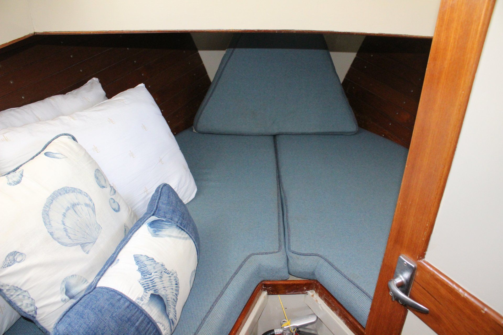 A blue and white pillow sits on a couch in a boat