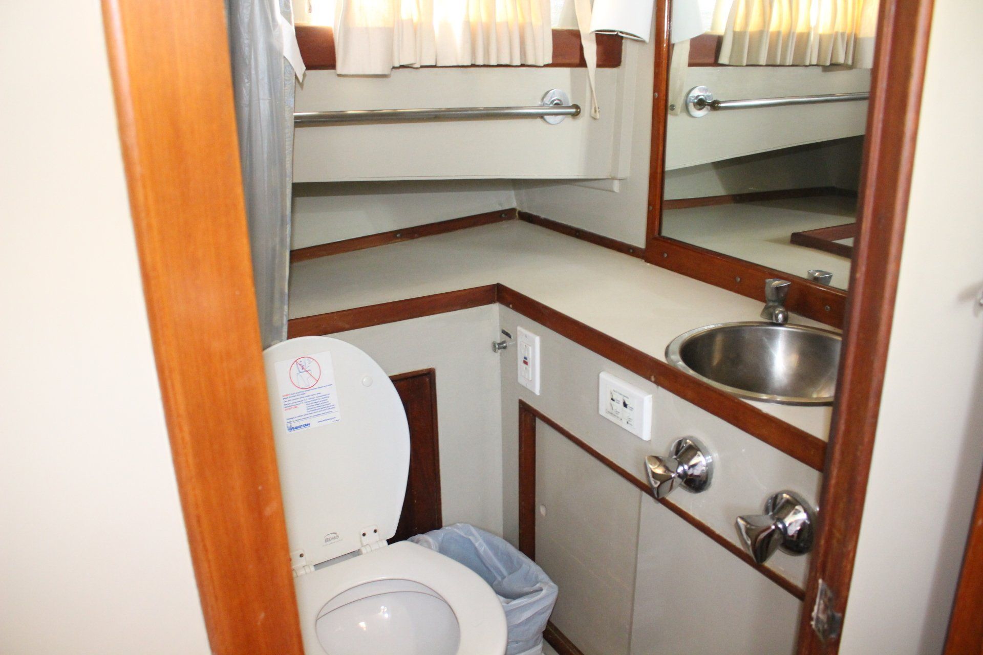 A bathroom with a toilet a sink and a mirror