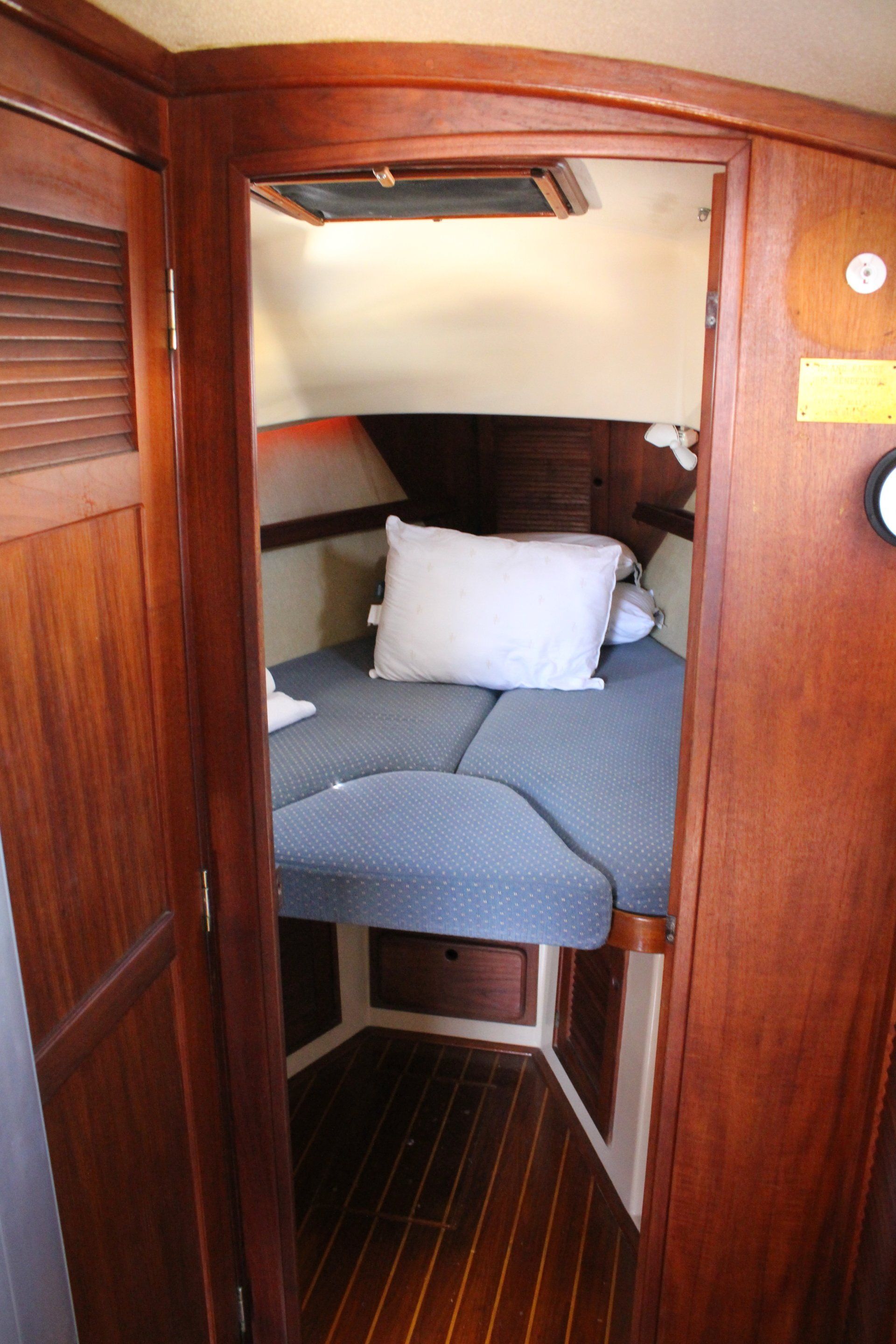A bedroom on a boat with a bed and pillows