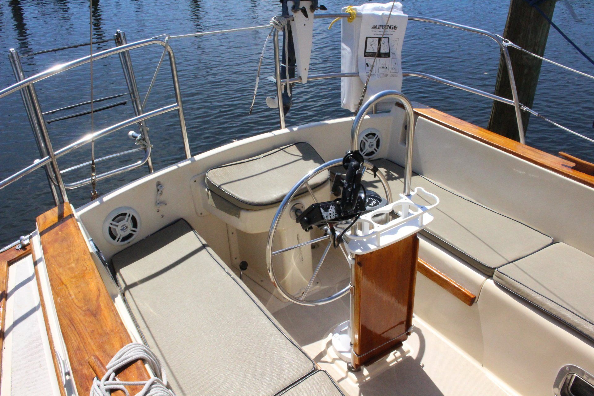 A boat with a steering wheel and a cooler on the deck