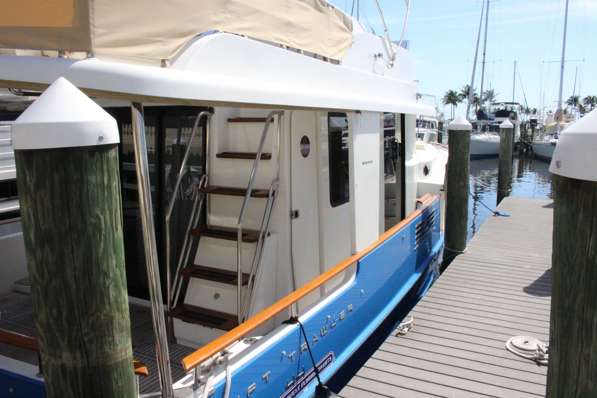A blue and white boat is docked at a dock