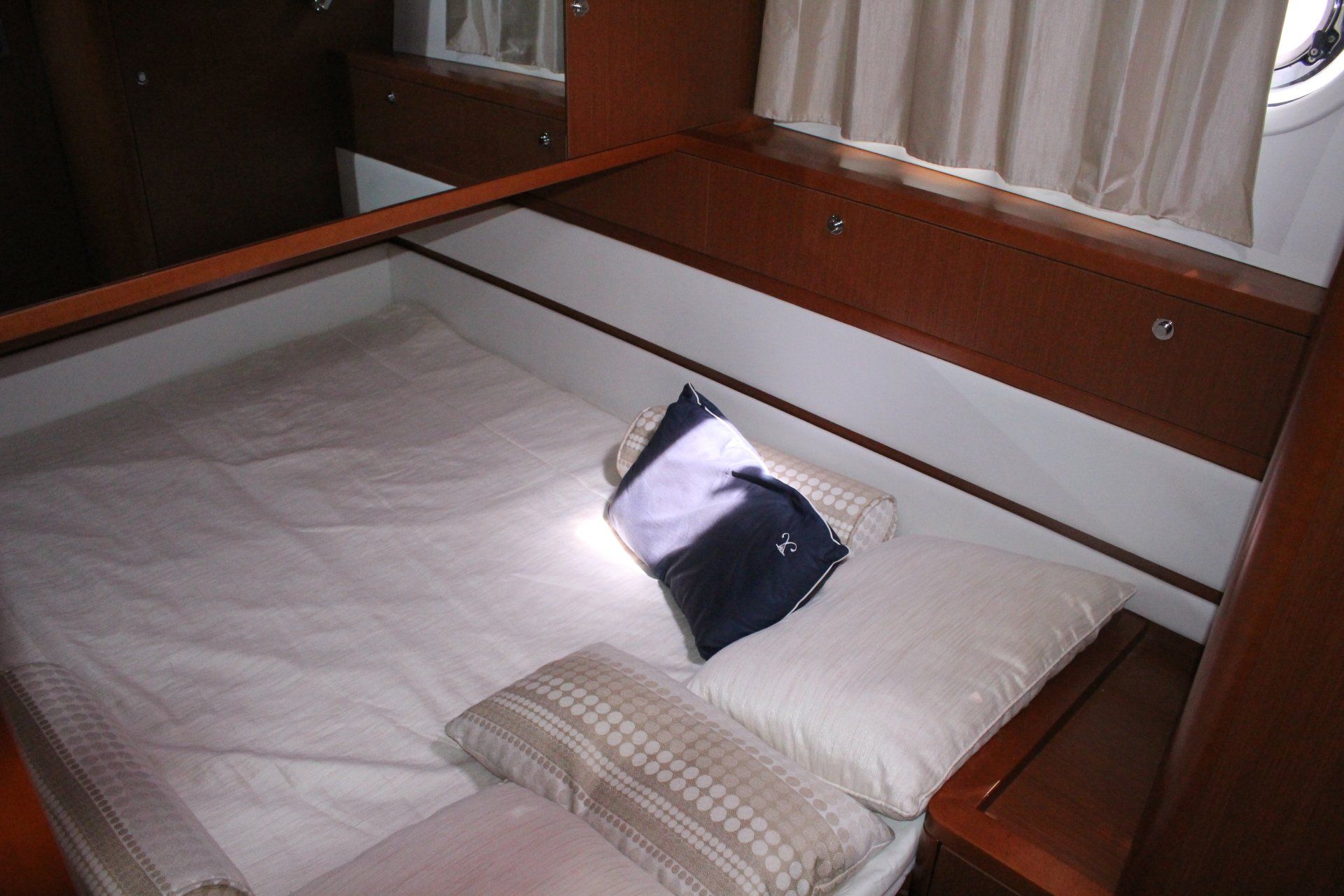 A bed with a blue and white pillow on it