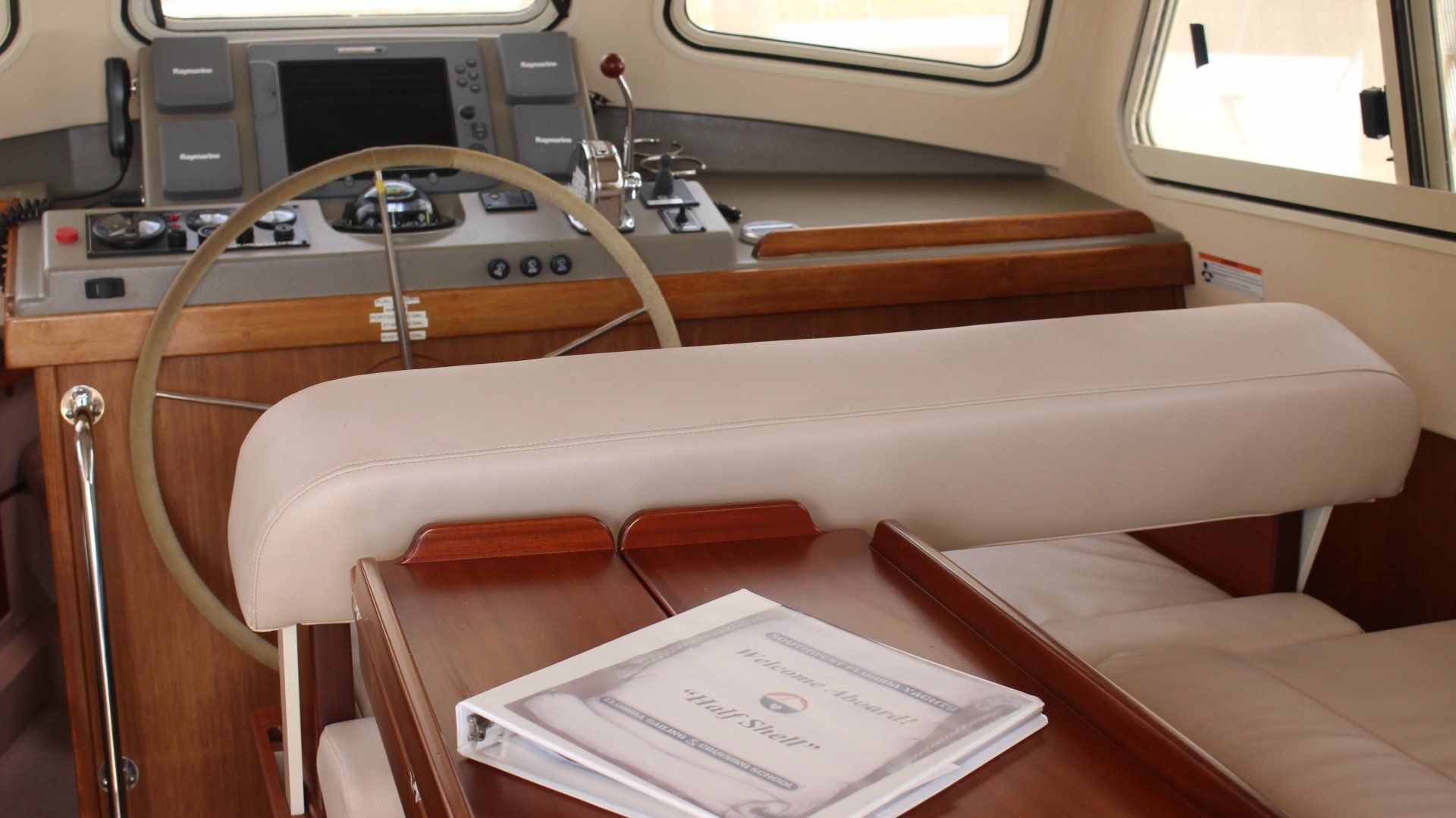 The inside of a boat with a table and a steering wheel