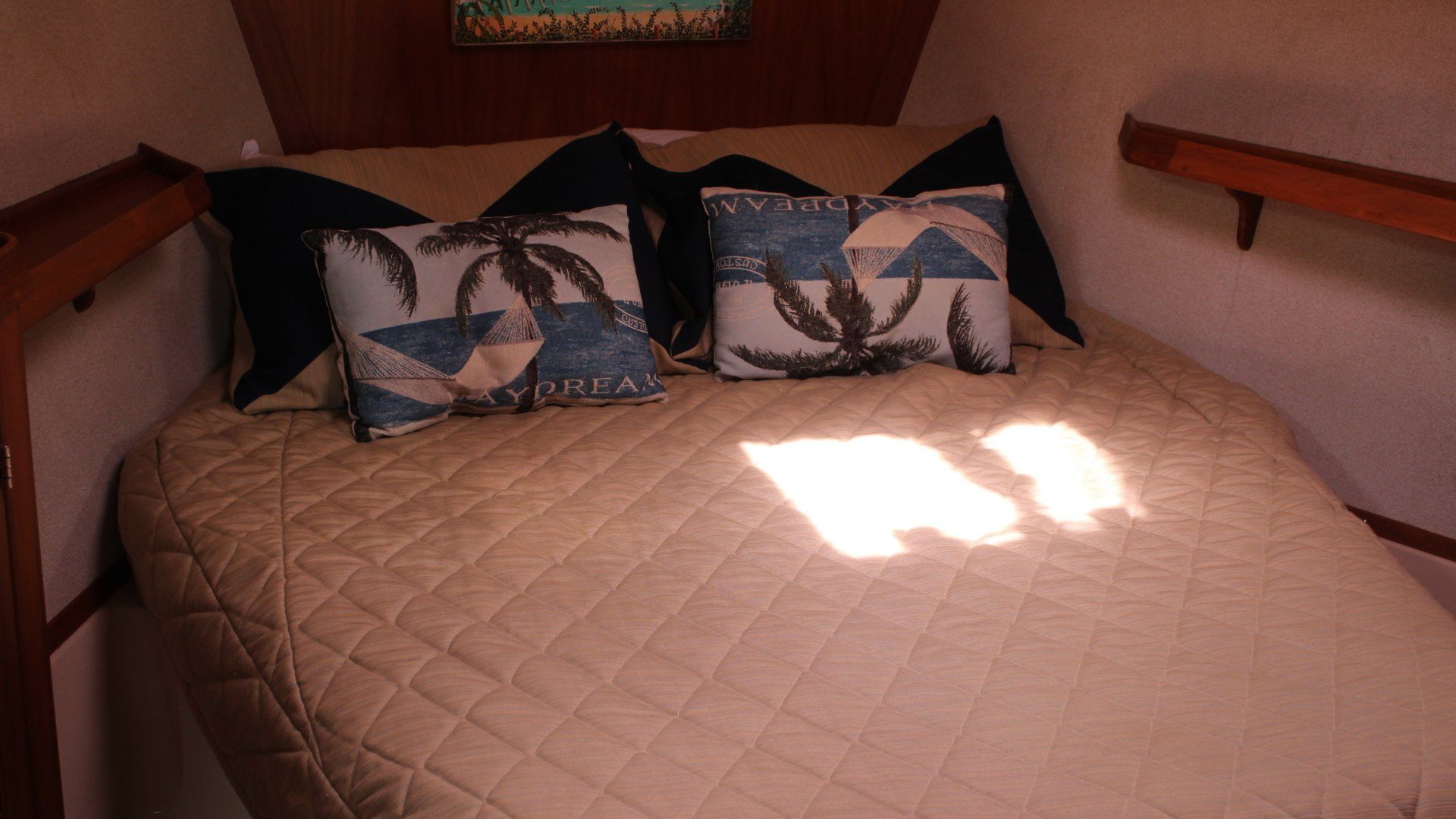 A bed with a quilt and pillows on it in a room.