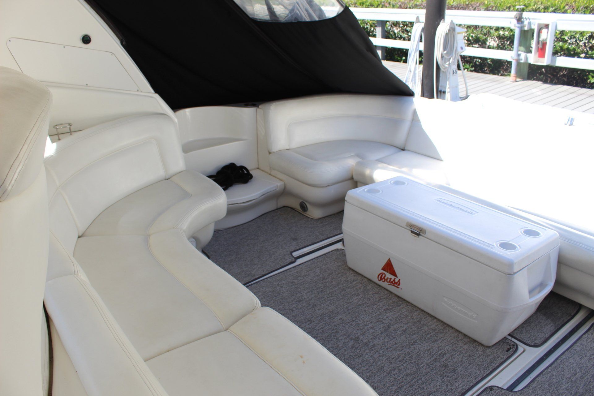 A white cooler with a red triangle on it sits on a boat