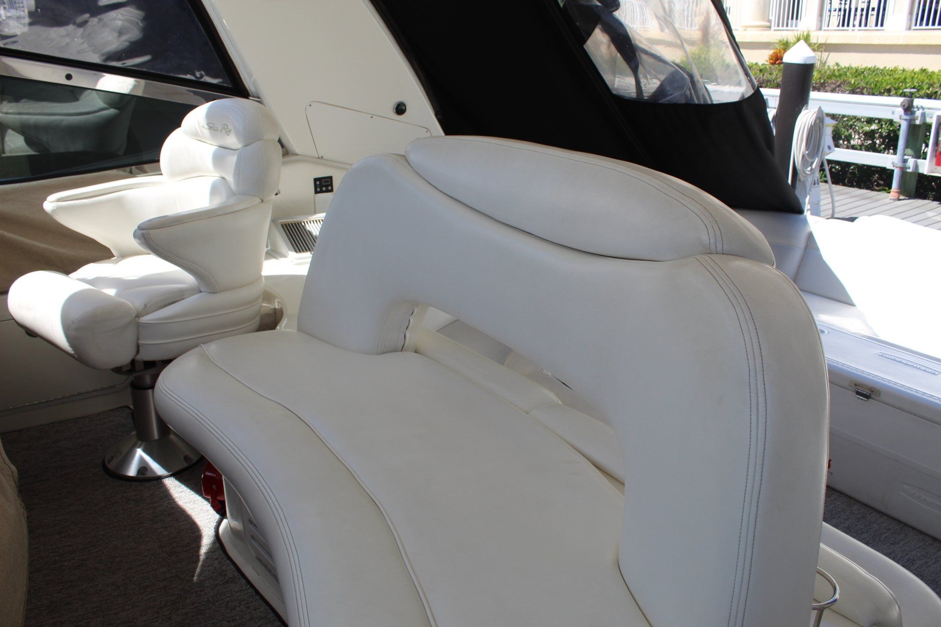 A white seat on a boat with a cushion on it