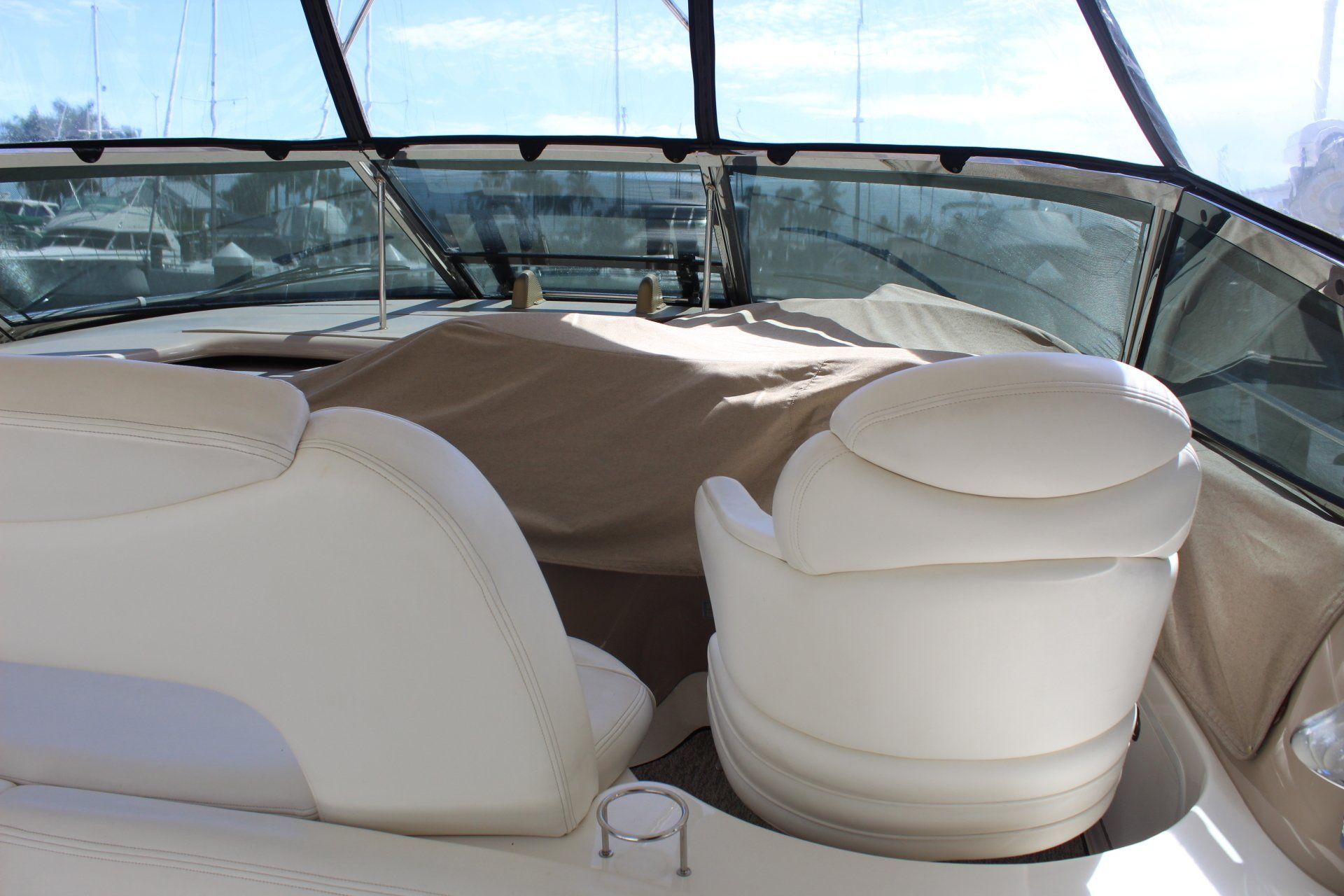 A boat with white seats and a brown blanket on it