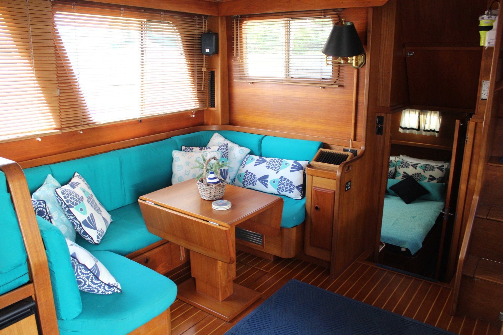 A living room on a boat with blue couch and table
