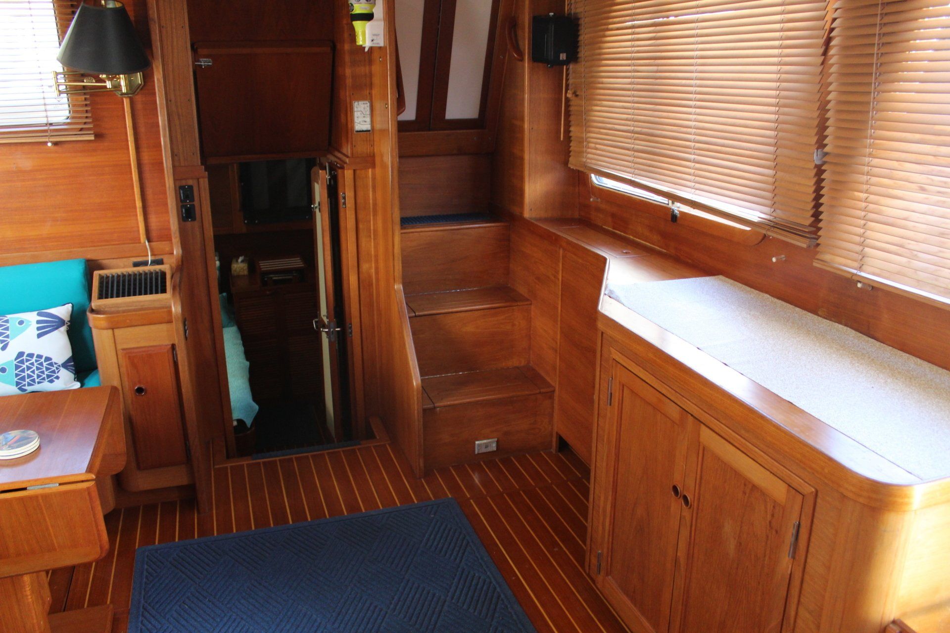 The inside of a boat with wooden cabinets and stairs