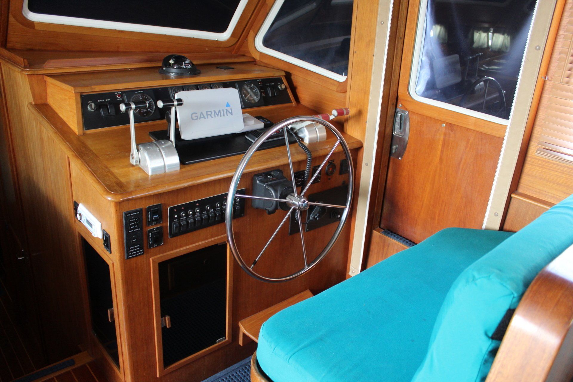 A boat with a steering wheel and a blue seat